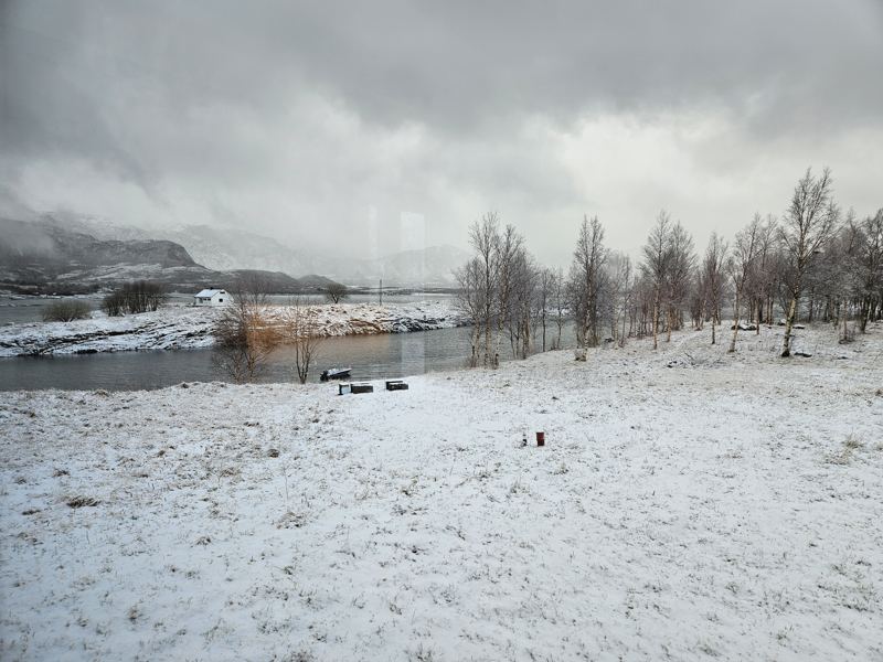 Snødekt landskap ved vannet