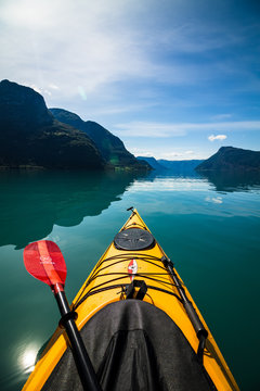 Kajakk på fjord mellom fjell